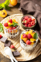 Summer healthy diet breakfast, snack concept. Triffle of chocolate biscuit with yogurt and fresh berries and fruits. Two portioned glass parfafait dessert.