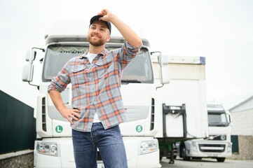 Portrait of trucker standing by his truck ready for driving. Driver occupation. Transportation services