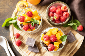 Summer healthy diet breakfast, snack concept. Triffle of chocolate biscuit with yogurt and fresh berries and fruits. Two portioned glass parfafait dessert. View from above.