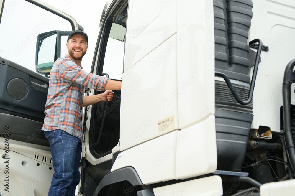 Wall mural caucasian male truck driver stepping out of vehicle at rest stop.