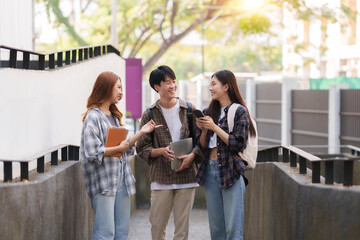 Group Of Young Asian Students Collaborating Outdoors at University. Teamwork and Knowledge Sharing. Asian Students Engaged in Collaborative Learning Outdoors.
