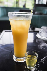 Wedhang Jahe Serai in a long glass or Cold Lemongrass Ginger drink. Traditional drink used as herbal medicines for health, relaxation and stamina or to overcome body chills. Close-up photo.