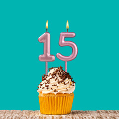 Birthday card with number 15 candle on aquamarine background