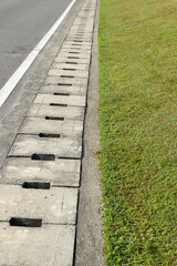 Drainage ditch on the side of the road and green grass