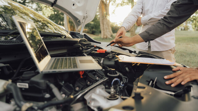 Man inspecting and servicing the engine, bonnet, safety test tool before the customer is on a long trip	