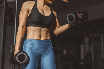 Fototapeta na wymiar Concepts healthy lifestyle and workout. Bodybuilder, Workout, Fitness muscular body, Fitness, Gym. Fitness asian woman doing exercise and lifting dumbbells weights, bodyweight at sport gym