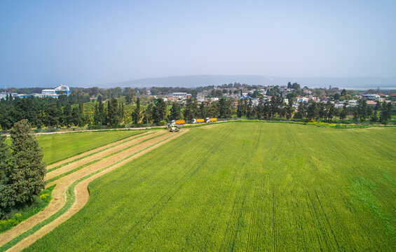 Aerial view of a agricultural machinery at action in a wheat field, kibbutz saar, Israel.