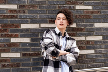 Fototapeta na wymiar young man posing against a brick wall