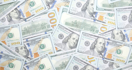 A pile of one hundred US banknotes with president portraits.