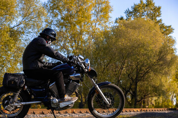 angry motorcyclist maniac in helmet and mask on custom vintage motorcycle in bobber style