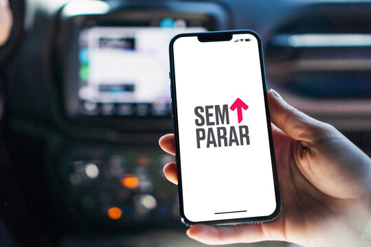 Girl inside car holding smartphone with Sem Parar app on screen. Rio de Janeiro, RJ, Brazil. July 12 2023