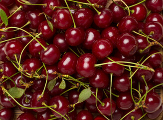 Fresh cherry with leaves as backgroung, top view