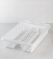 Fototapeta na wymiar Plastic white dish dryer. Accessories for the kitchen, washing dishes.