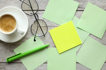 note paper, yellow sticker and a cup with coffee glasses on the table. Mockup on office copy space...