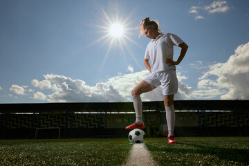 sports girl football player with a soccer ball on the soccer field, the concept of professional women's football
