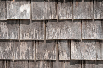 Close-up view of large gray weathered shingles on typical Cape Cod building in quaint fishing village on Martha's Vineyard, Massachusetts.

