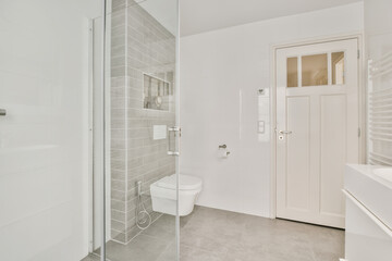 a modern bathroom with white walls and grey flooring, including a glass shower door that opens to the walk - in shower area