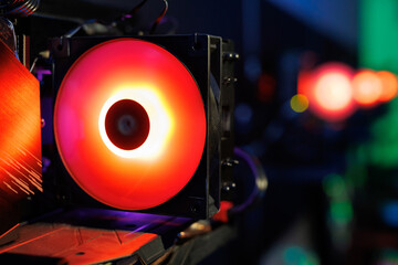Top-end system unit with fans for a gaming computer in close-up with neon illumination.