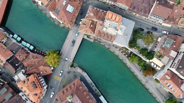 Thun, Switzerland: Aerial top down drone footage of the Thun medieval old town along the aar river in canton Bern in Switzerland