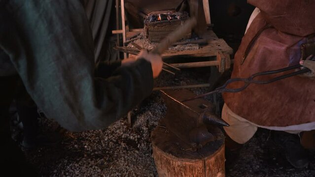Turning iron. Media. Processionals work to shape the iron in with special hammers.