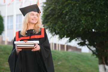 Happy graduation day for a young woman very beautiful with graduation cap smile large, while...