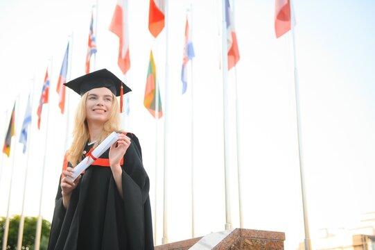 Young woman with beautiful smile in graduation gown. The concept of international education.