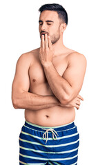 Fototapeta premium Young handsome man wearing swimwear bored yawning tired covering mouth with hand. restless and sleepiness.