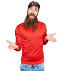 Redhead man with long beard wearing casual clothes clueless and confused expression with arms and...