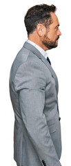 Middle age man wearing business clothes looking to side, relax profile pose with natural face and confident smile.