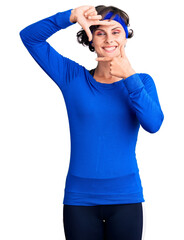 Beautiful young woman with short hair wearing training workout clothes smiling making frame with hands and fingers with happy face. creativity and photography concept.