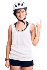 Beautiful young woman with short hair wearing bike helmet smiling happy pointing with hand and finger to the side