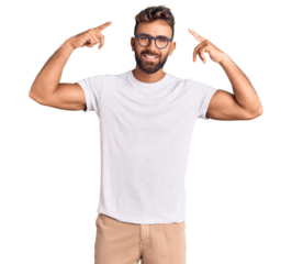 Young hispanic man wearing casual clothes and glasses smiling pointing to head with both hands finger, great idea or thought, good memory