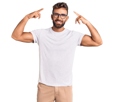 Young hispanic man wearing casual clothes and glasses smiling pointing to head with both hands finger, great idea or thought, good memory