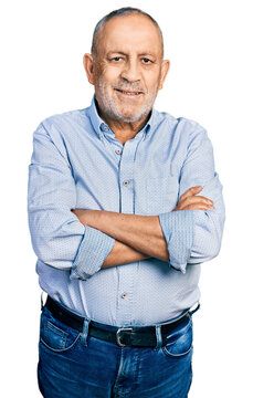 Senior man with grey hair and beard with arms crossed gesture smiling with a happy and cool smile on face. showing teeth.