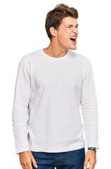 Handsome caucasian man wearing casual white sweater angry and mad screaming frustrated and furious, shouting with anger. rage and aggressive concept.