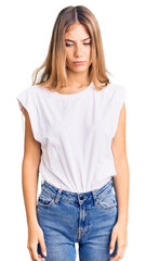 Fototapeta premium Beautiful caucasian woman with blonde hair wearing casual white tshirt depressed and worry for distress, crying angry and afraid. sad expression.