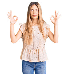 Fototapeta na wymiar Beautiful caucasian woman with blonde hair wearing elegant summer clothes relax and smiling with eyes closed doing meditation gesture with fingers. yoga concept.