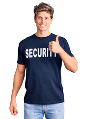 Fototapeta premium Young handsome man wearing security t shirt doing happy thumbs up gesture with hand. approving expression looking at the camera showing success.