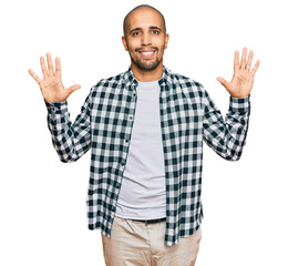 Hispanic adult man wearing casual clothes showing and pointing up with fingers number ten while smiling confident and happy.