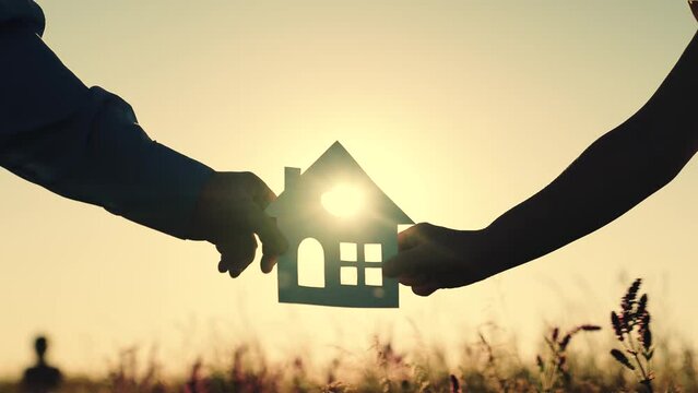 construction  residential building. sign symbol house  woman man holding paper house sunset. happy family lifestyle. silhouette sunlight window. credit epoteka loan purchase housing. ecology sunset