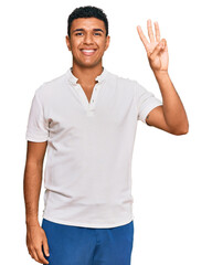 Young arab man wearing casual clothes showing and pointing up with fingers number three while smiling confident and happy.