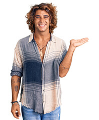 Young hispanic man wearing summer style smiling cheerful presenting and pointing with palm of hand looking at the camera.