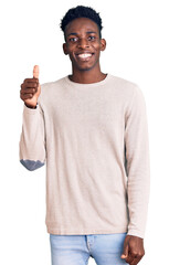 Young african american man wearing casual clothes smiling happy and positive, thumb up doing excellent and approval sign