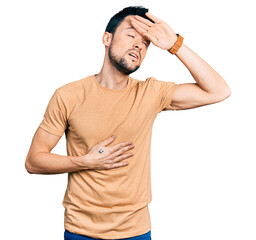 Hispanic man with beard wearing casual t shirt touching forehead for illness and fever, flu and cold, virus sick