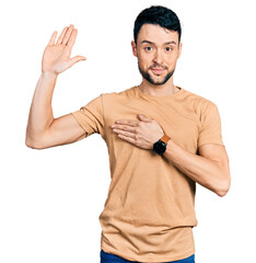 Hispanic man with beard wearing casual t shirt swearing with hand on chest and open palm, making a...
