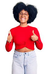 Young african american girl wearing casual clothes and glasses success sign doing positive gesture with hand, thumbs up smiling and happy. cheerful expression and winner gesture.