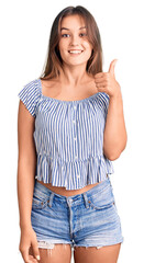 Beautiful caucasian woman wearing casual clothes smiling happy and positive, thumb up doing excellent and approval sign