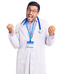 Young hispanic man wearing doctor uniform and stethoscope very happy and excited doing winner gesture with arms raised, smiling and screaming for success. celebration concept.