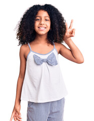 African american child with curly hair wearing casual clothes smiling with happy face winking at the camera doing victory sign. number two. - obrazy, fototapety, plakaty