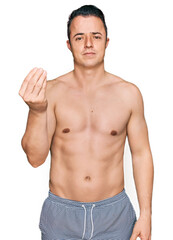 Fototapeta premium Handsome young man wearing swimwear shirtless doing italian gesture with hand and fingers confident expression